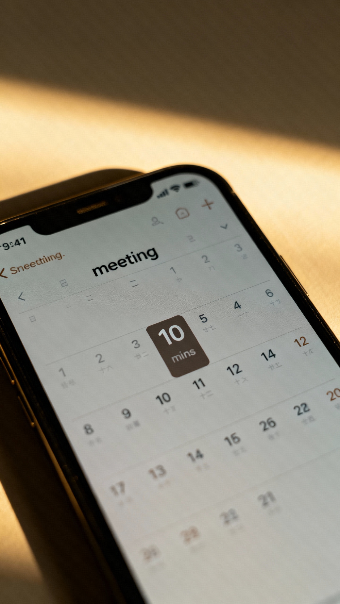 Closeup smartphone calendar showing 10-minute “meeting” block, muted notifications, soft sunligh