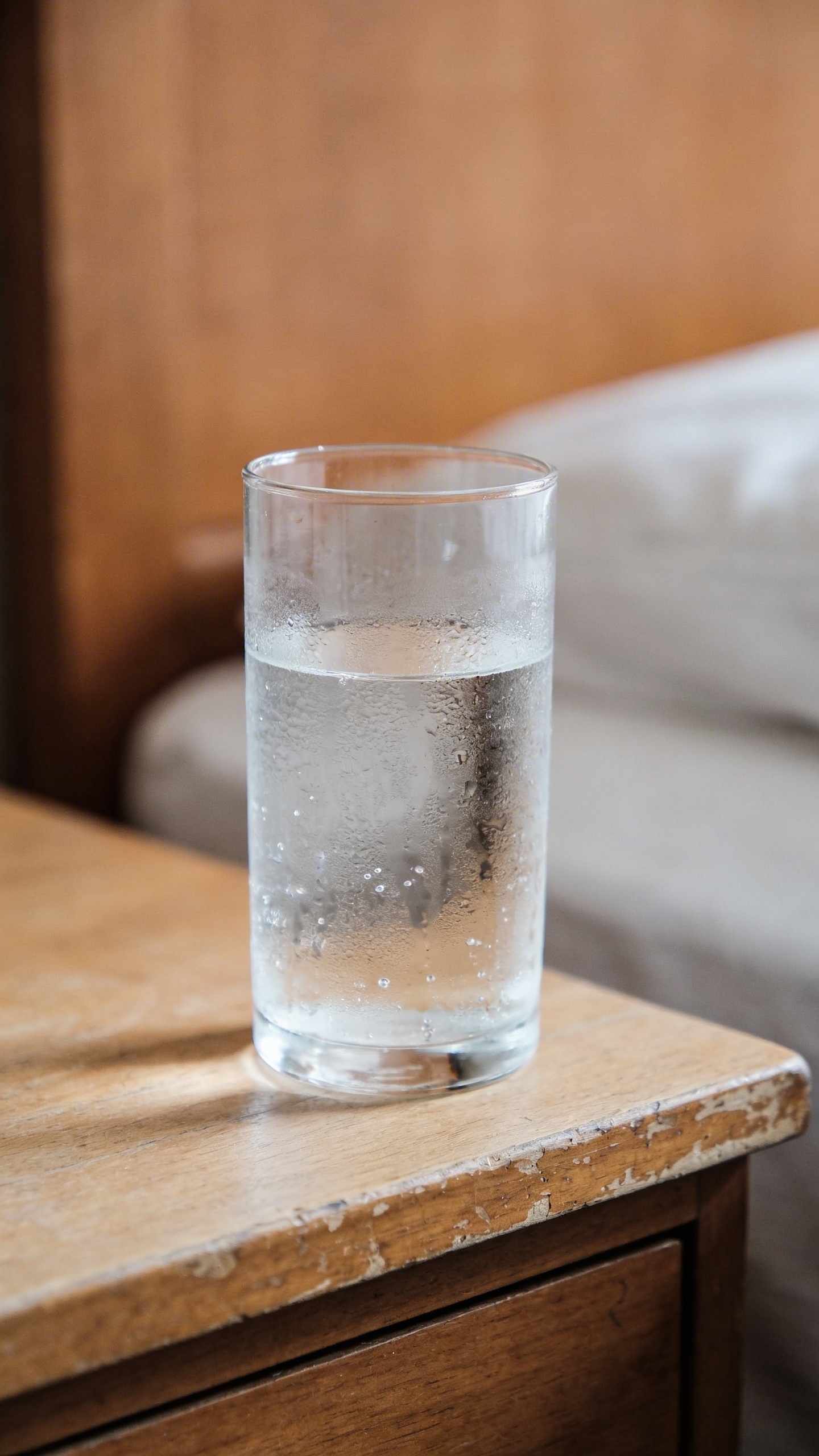 closeup of a single glass of water on a bedside table