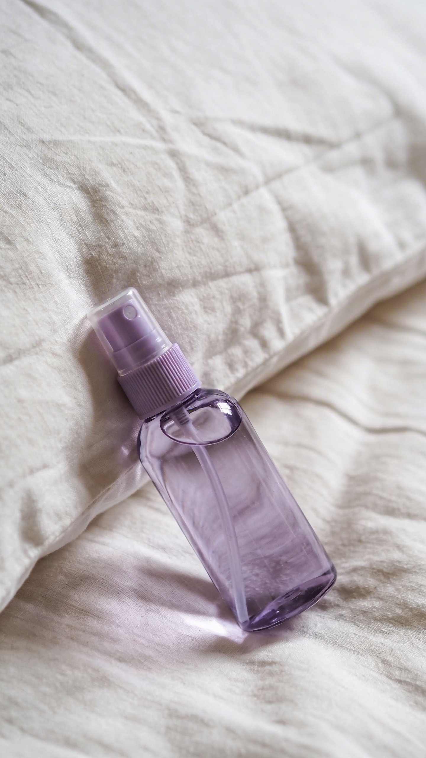 closeup lavender pillow spray bottle on linen sheets