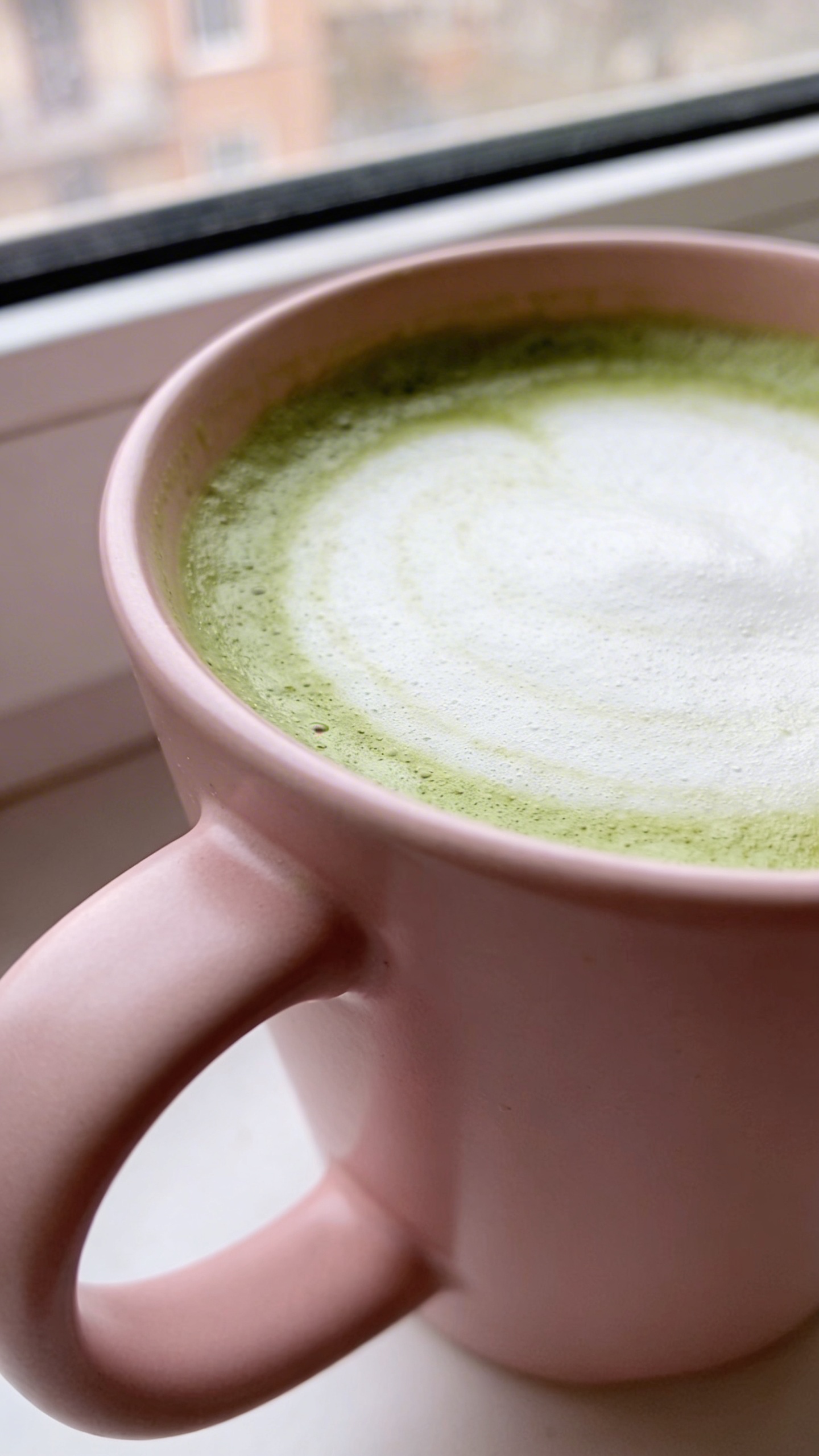 matcha latte in blush ceramic mug, soft window light