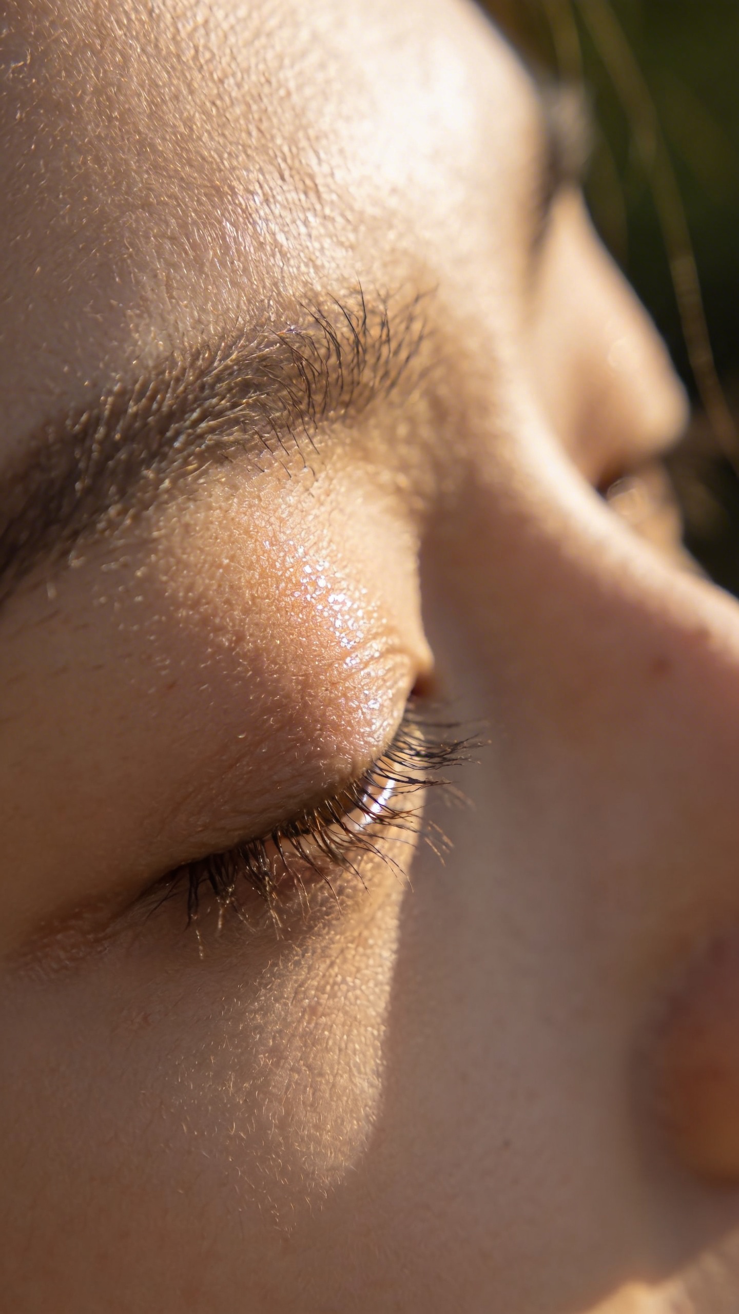 woman's closed eyes in sunlight, soft natural glow
