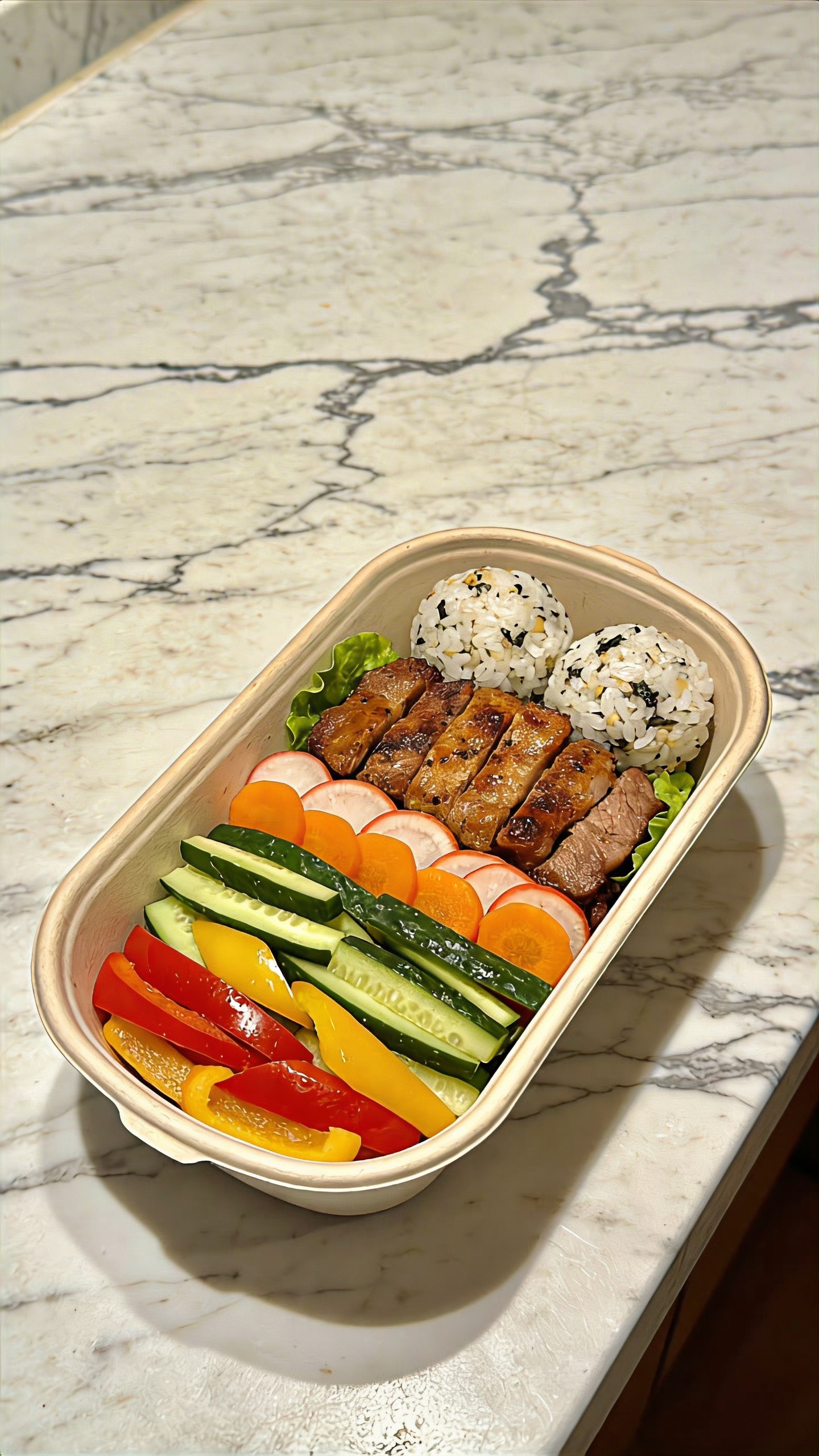single labeled bento-style lunchbox packed neatly on marble counter