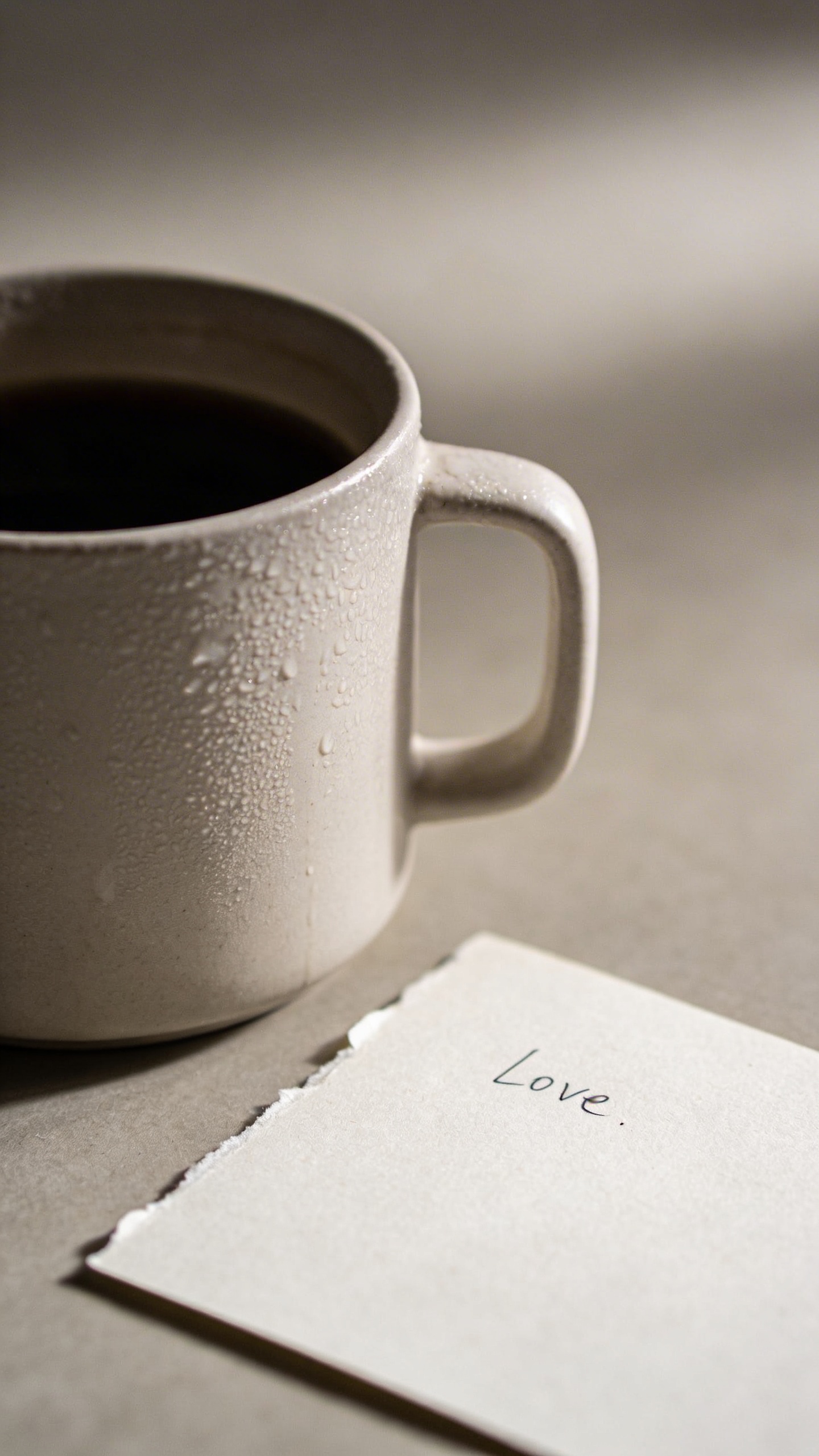 single cold coffee mug beside untouched love note