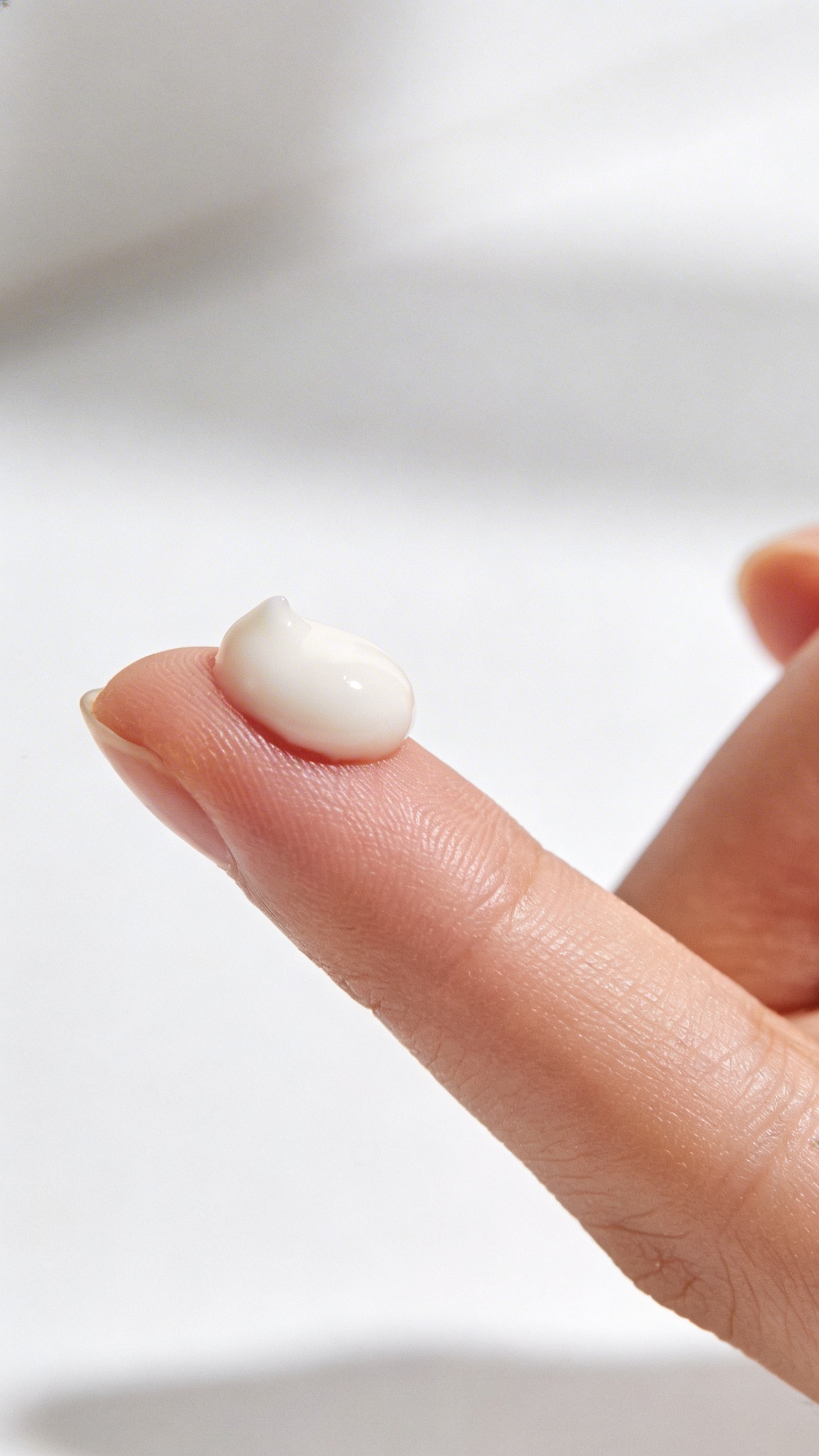 lightweight moisturizer pea-sized dollop on fingertip, clean background