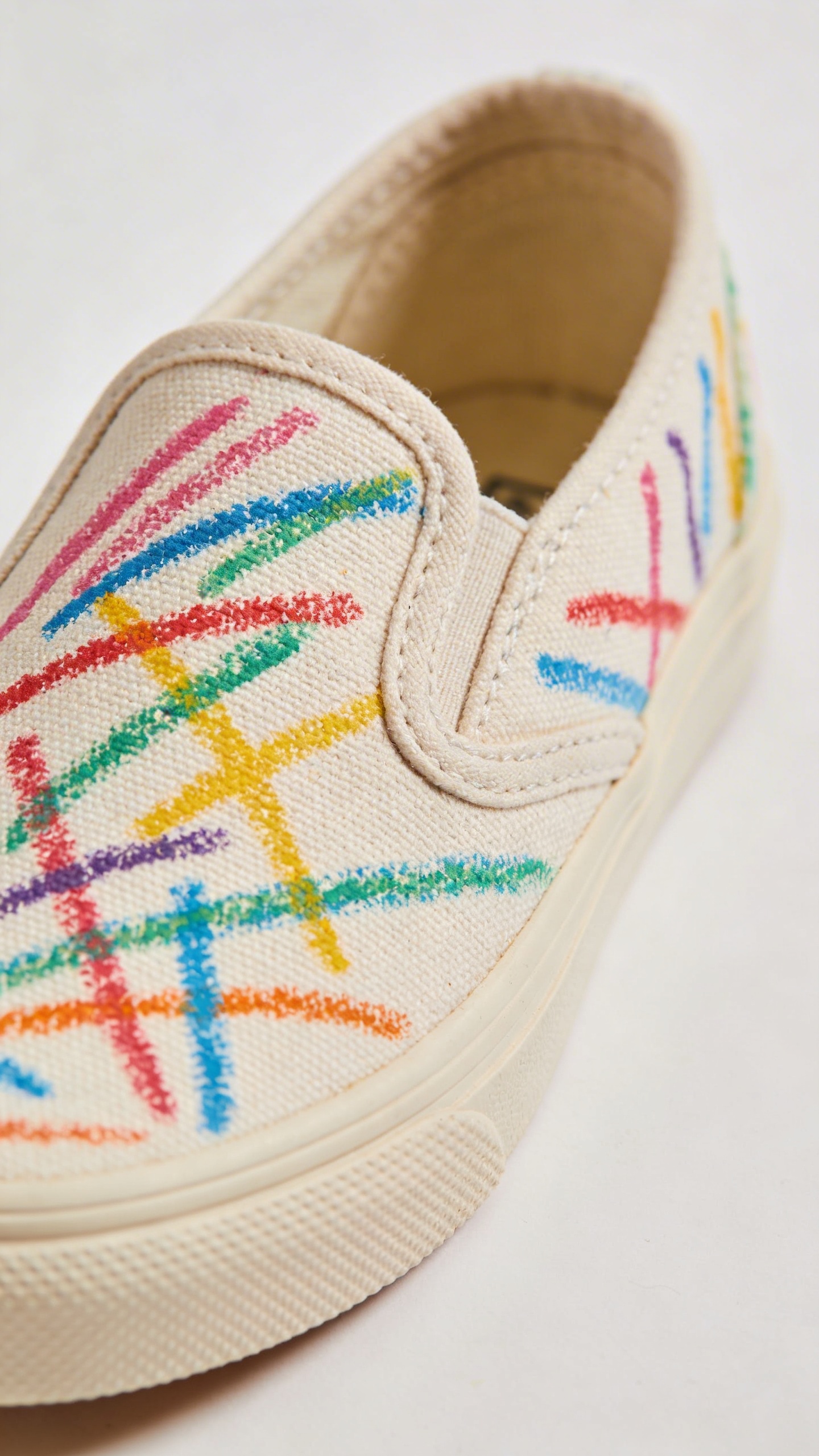 single slip-on sneaker with toddler crayon mark, studio lighting